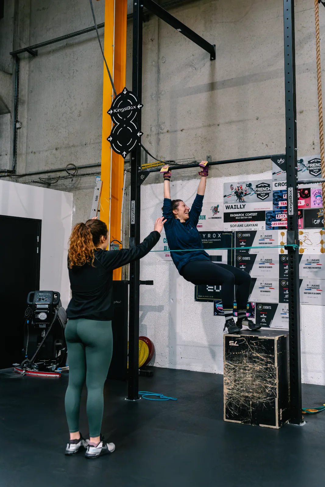 Coach guidant une adhérente en tête-à-tête sur un mouvement de barre chez CrossFit Giants, Saint-Ouen-l'Aumône