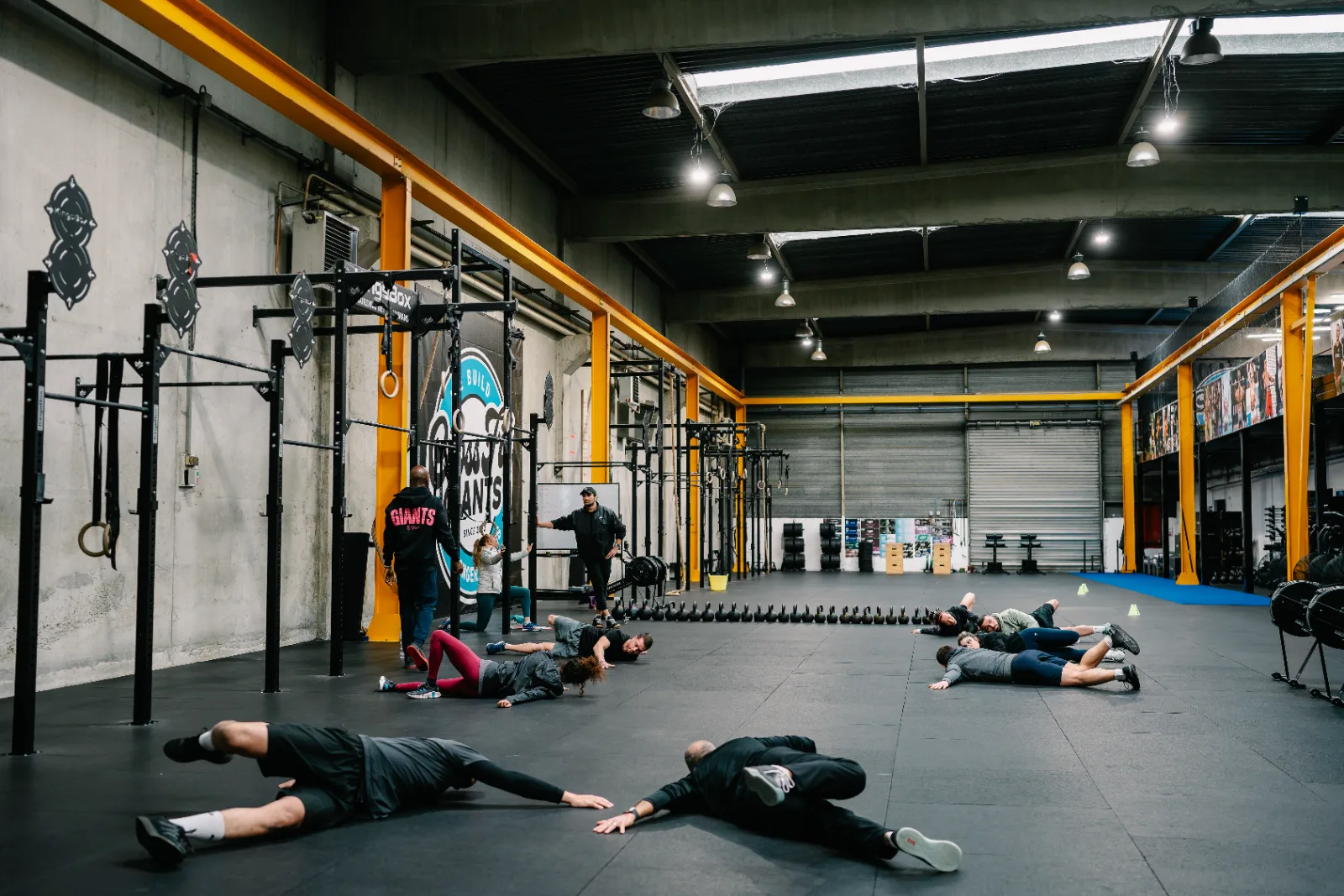 Cours collectif au sol pendant un échauffement dans la salle de 1300 m² de CrossFit Giants, Saint-Ouen-l'Aumône